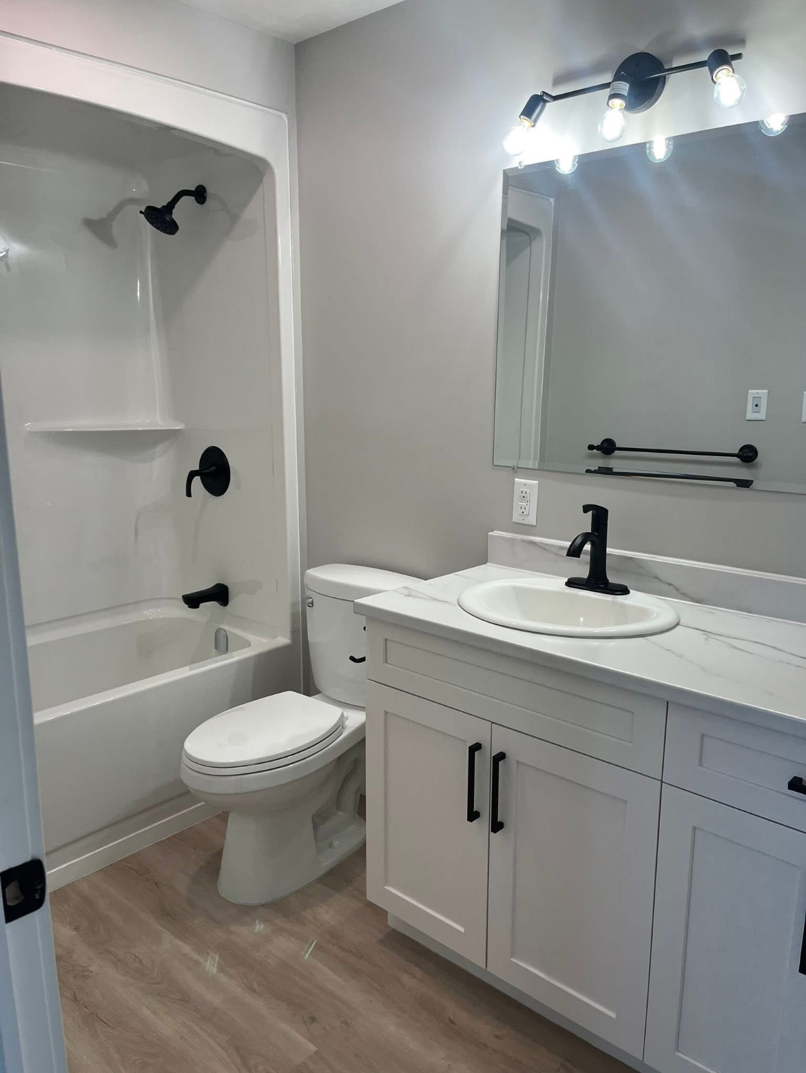 Full bathroom with tub and toilet in a 204 Bellevue Heights unit