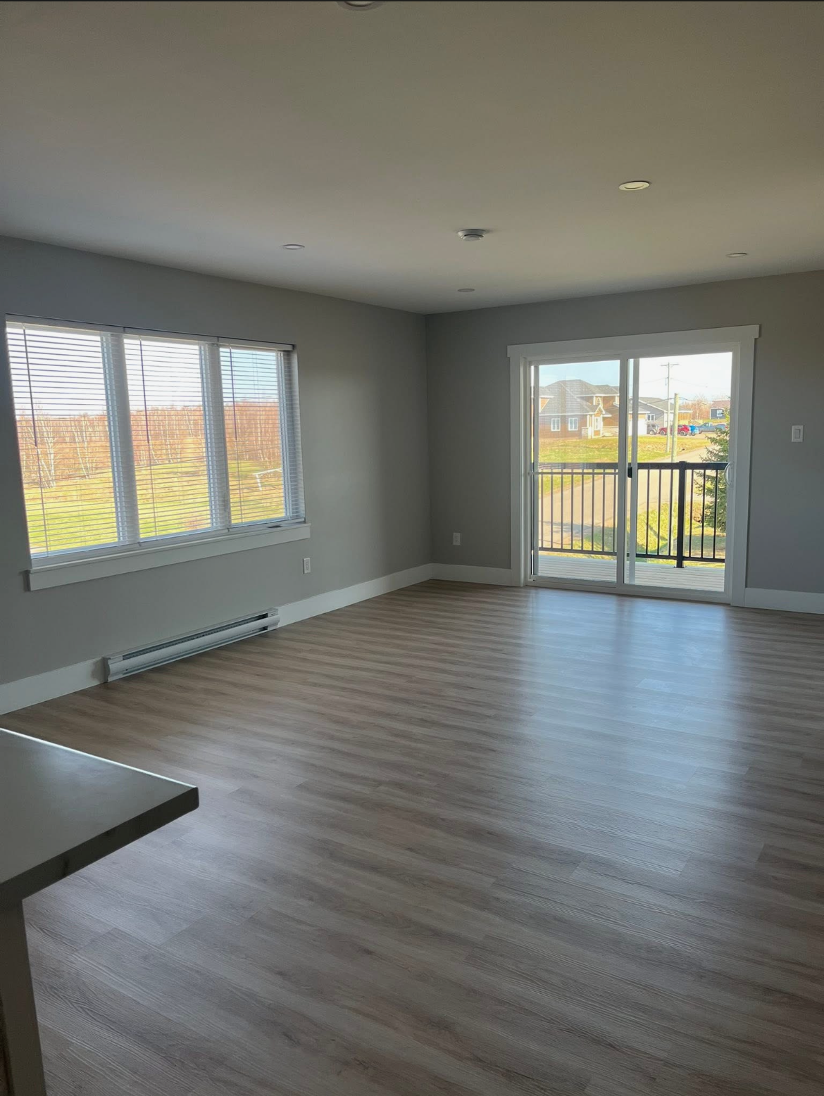 Living room with balcony access in a 204 Bellevue Heights unit